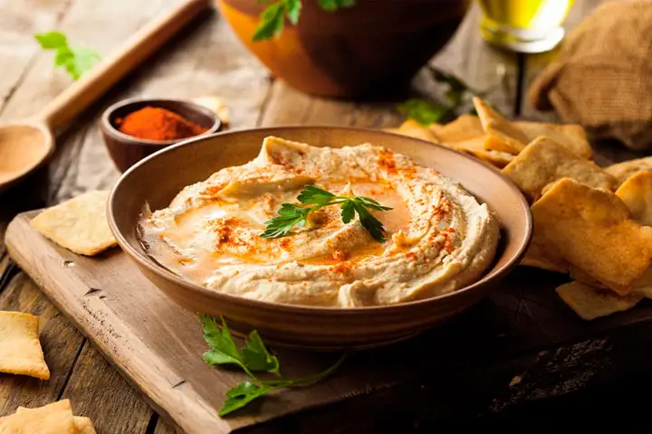 Creamy Hummus dip garnished with whole chickpeas and paprika